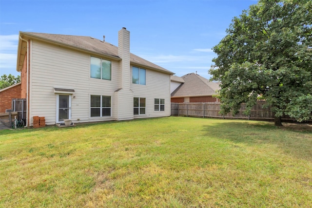 rear view of property featuring a yard