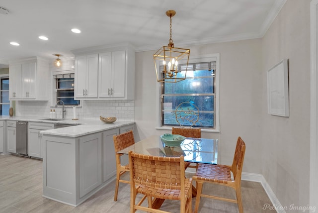 kitchen featuring white cabinetry, sink, backsplash, crown molding, and light wood-type flooring