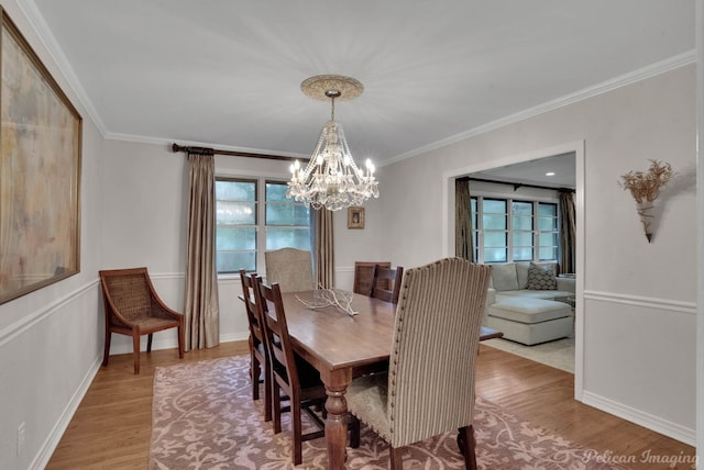 dining space featuring ornamental molding, plenty of natural light, a chandelier, and light hardwood / wood-style flooring