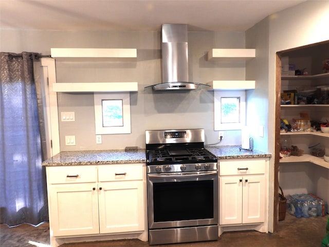 kitchen with light stone counters, stainless steel range with gas cooktop, and wall chimney range hood