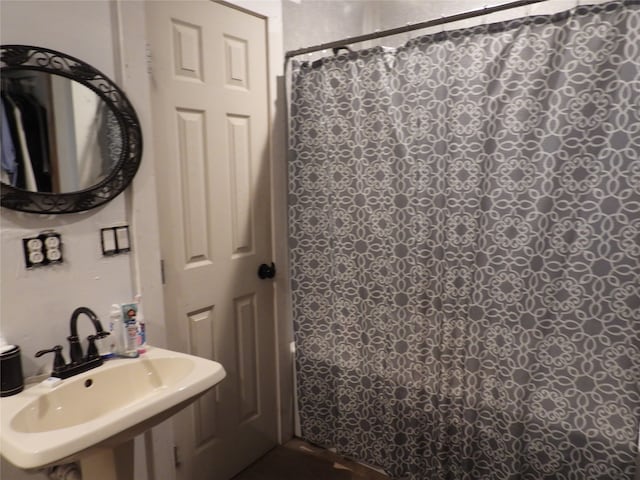 bathroom with curtained shower and sink