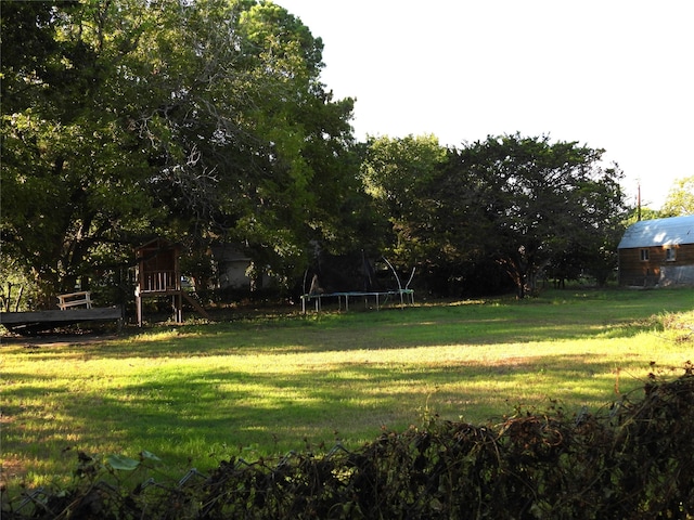 view of yard with a playground and a trampoline