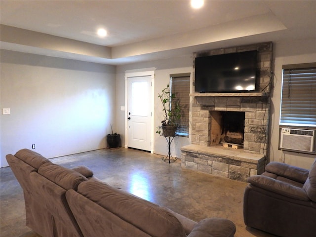 living room with a raised ceiling, a fireplace, and cooling unit