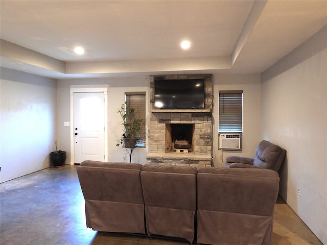 living room with a stone fireplace, cooling unit, and wood-type flooring