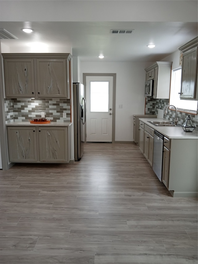 kitchen featuring a wealth of natural light, stainless steel appliances, sink, and backsplash