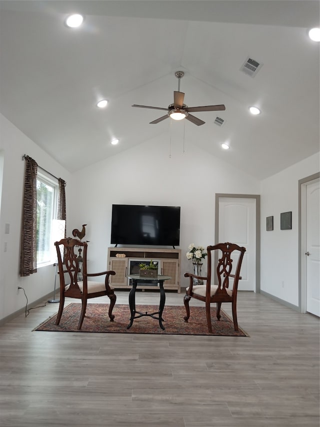 living room with lofted ceiling, ceiling fan, and light hardwood / wood-style floors