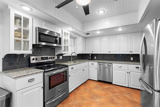 kitchen with ceiling fan, light stone countertops, appliances with stainless steel finishes, and white cabinetry