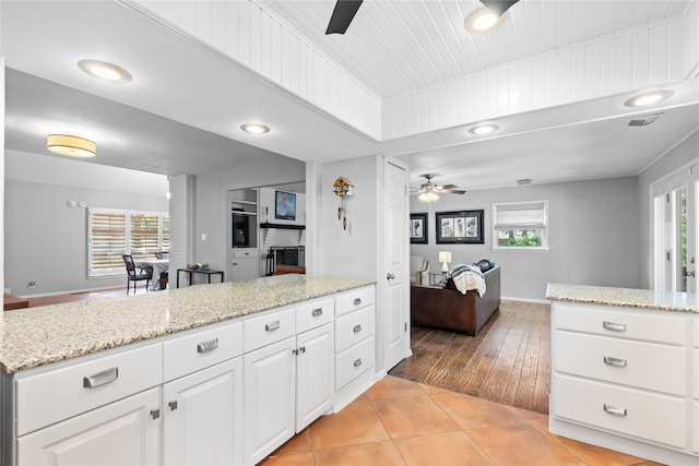 kitchen featuring white cabinets, ceiling fan, light hardwood / wood-style floors, and a healthy amount of sunlight