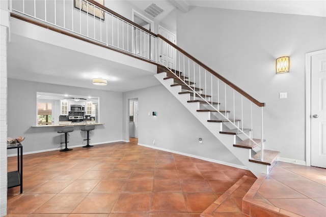 tiled foyer entrance featuring beamed ceiling