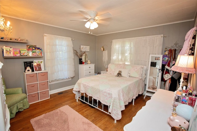 bedroom featuring ornamental molding, ceiling fan with notable chandelier, and dark wood-type flooring