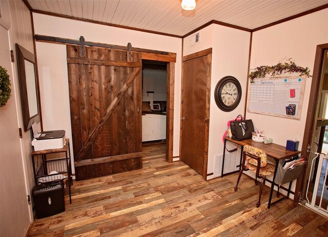 interior space featuring ornamental molding, light hardwood / wood-style flooring, a barn door, and wooden ceiling