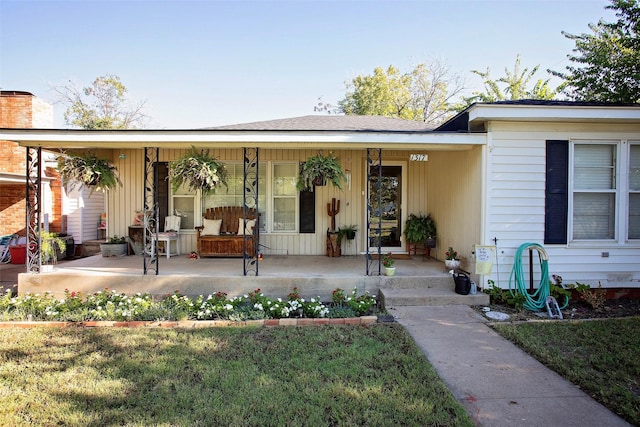 exterior space with covered porch and a yard