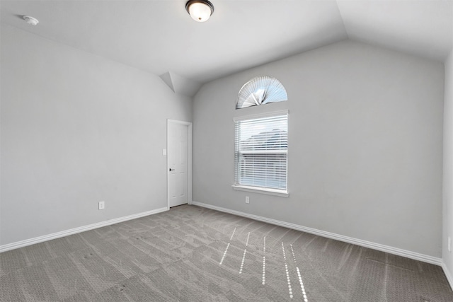 unfurnished room featuring carpet flooring and vaulted ceiling