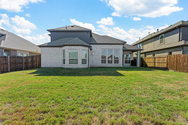 rear view of house featuring a lawn