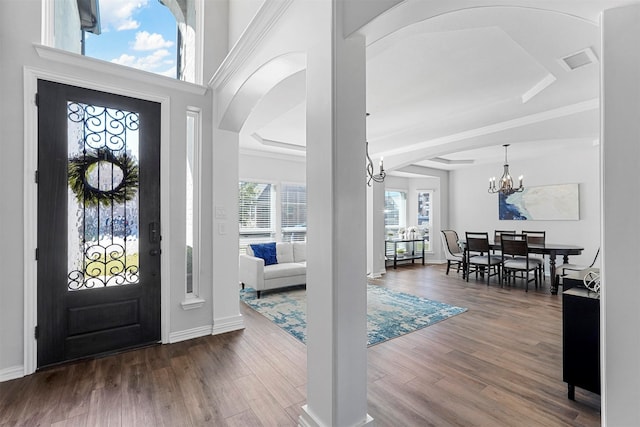 entryway with a raised ceiling, an inviting chandelier, and dark hardwood / wood-style floors