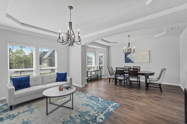 living room featuring a wealth of natural light, a raised ceiling, a notable chandelier, and dark hardwood / wood-style flooring