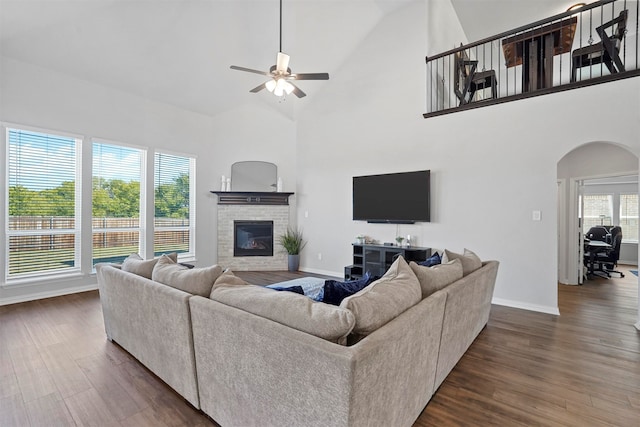 living room featuring dark wood-type flooring, ceiling fan, and high vaulted ceiling