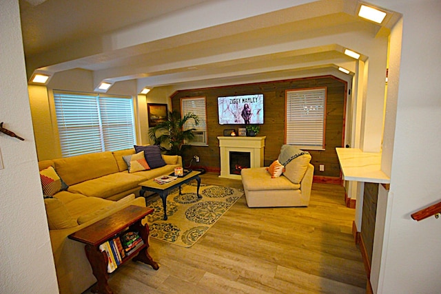 living area with a warm lit fireplace and wood finished floors