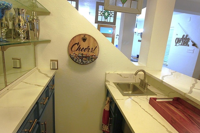 interior space with light stone counters and a sink