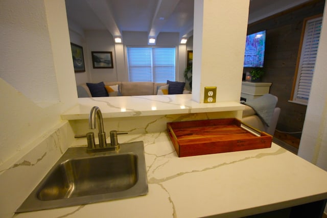 kitchen with a sink and light stone countertops
