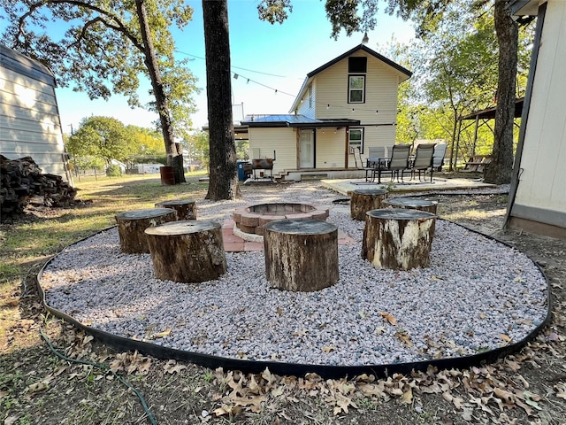 back of house featuring an outdoor fire pit and a patio