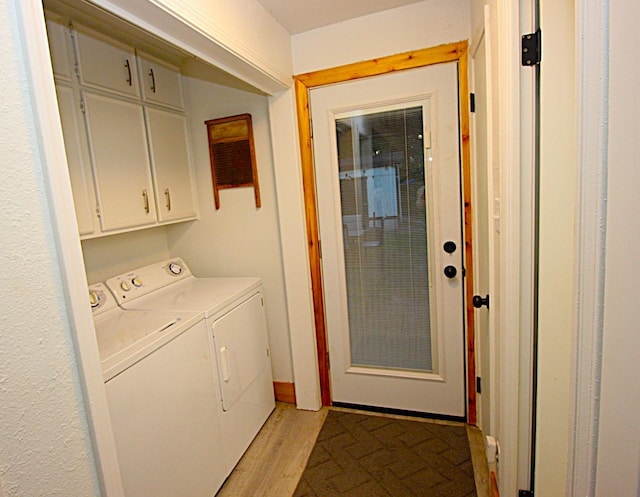 laundry room with light wood-style flooring, cabinet space, and washing machine and dryer