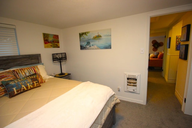 bedroom featuring heating unit, baseboards, and dark carpet