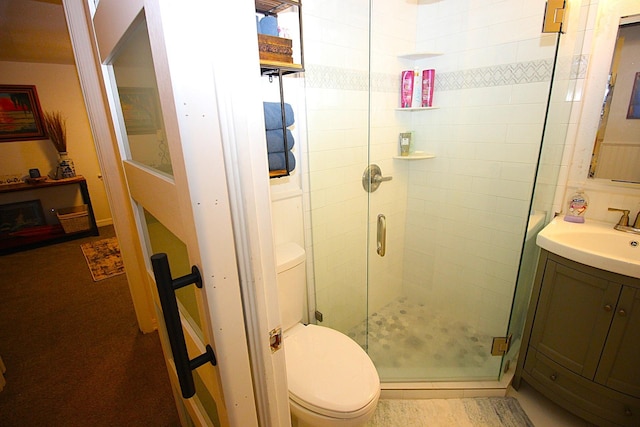 bathroom featuring vanity, toilet, and a shower stall