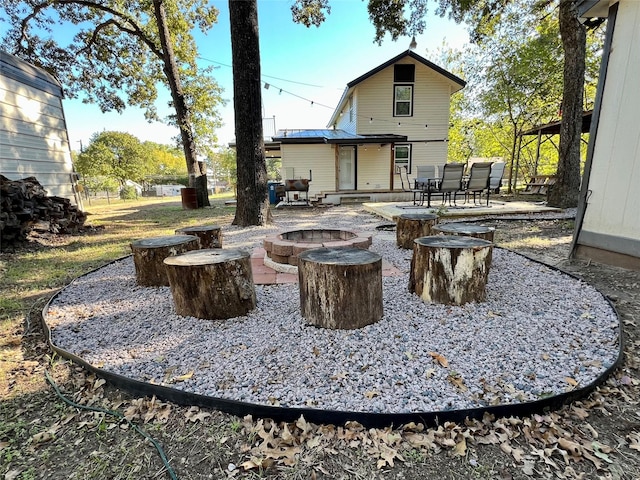 back of property featuring a patio, a fire pit, and outdoor dining space