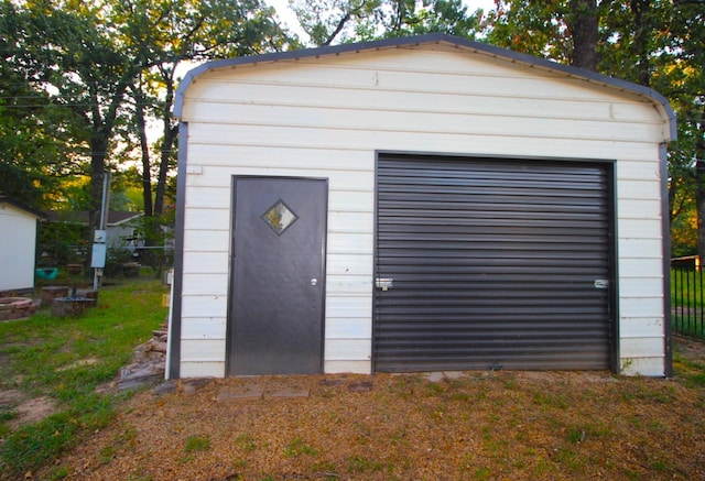 garage with fence and a shed