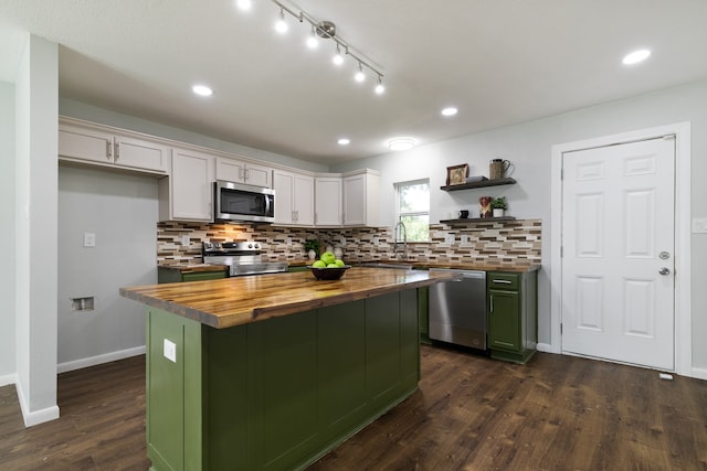 kitchen with appliances with stainless steel finishes, white cabinetry, dark wood-type flooring, butcher block countertops, and a kitchen island