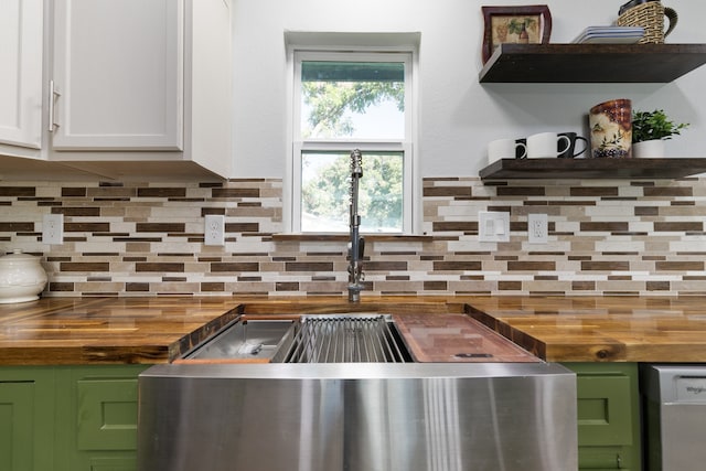 kitchen with white cabinetry, butcher block counters, and tasteful backsplash