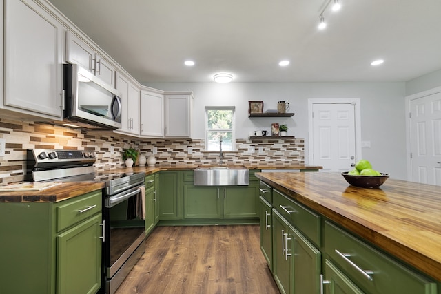 kitchen featuring appliances with stainless steel finishes, green cabinets, wooden counters, and white cabinetry