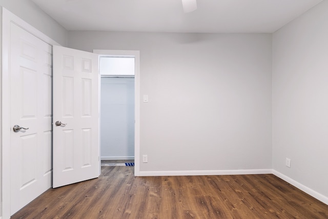 unfurnished bedroom featuring ceiling fan and dark hardwood / wood-style flooring