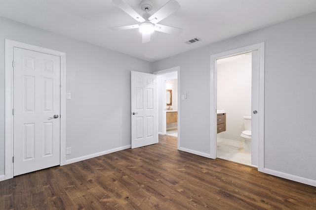 unfurnished bedroom featuring dark hardwood / wood-style flooring, ceiling fan, and ensuite bath