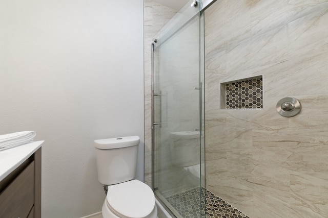 bathroom with walk in shower, vanity, and toilet