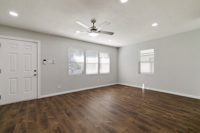 empty room with dark hardwood / wood-style flooring and ceiling fan