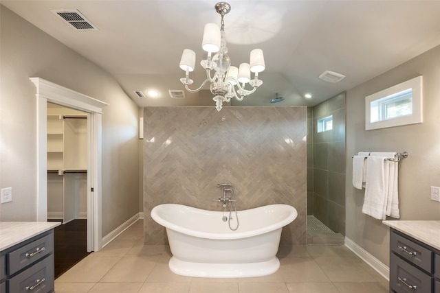 bathroom with tile patterned floors, vanity, tile walls, and a notable chandelier