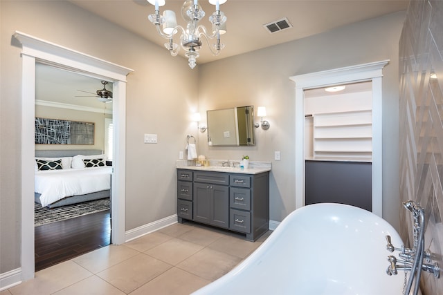 bathroom featuring hardwood / wood-style floors, vanity, ceiling fan with notable chandelier, crown molding, and a tub to relax in