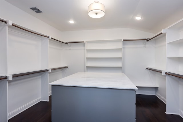 walk in closet with dark hardwood / wood-style flooring and lofted ceiling