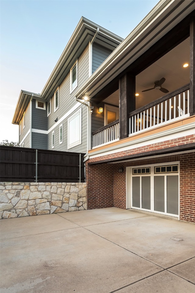 view of property exterior with a balcony, a garage, and ceiling fan