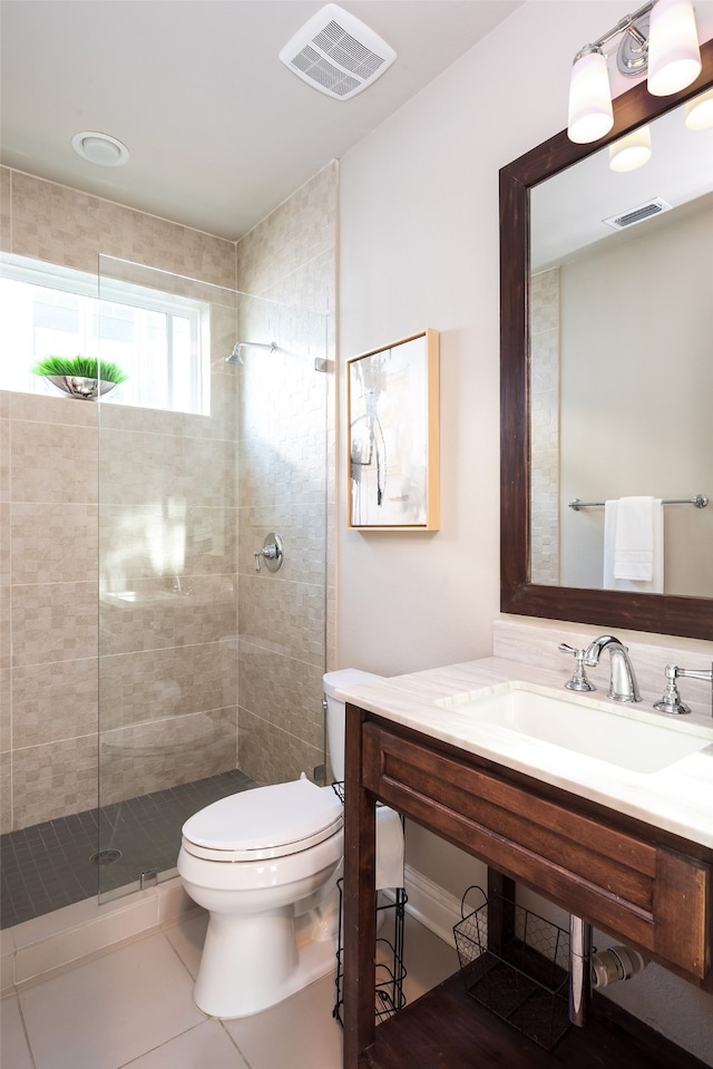 bathroom featuring tile patterned floors, vanity, tiled shower, and toilet