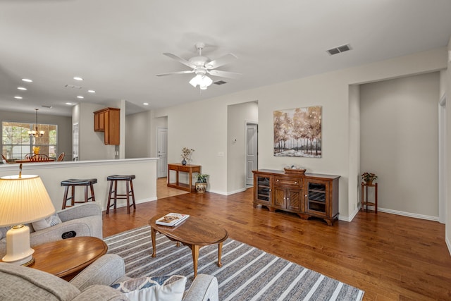 living room featuring hardwood / wood-style floors and ceiling fan with notable chandelier