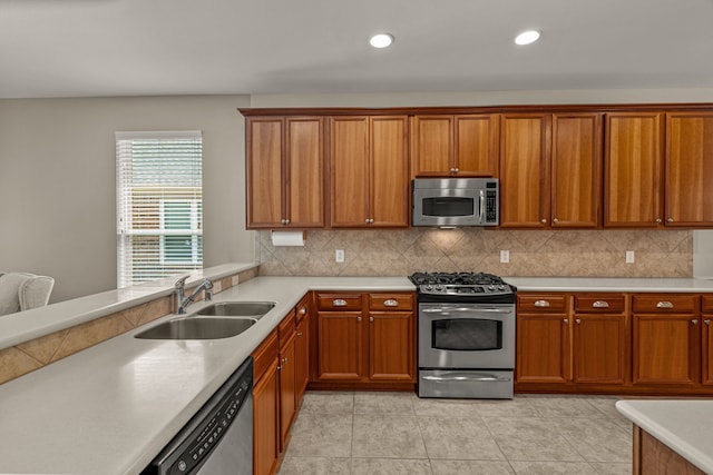 kitchen with backsplash, sink, light tile patterned floors, and appliances with stainless steel finishes