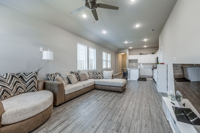 living room with light hardwood / wood-style flooring and ceiling fan