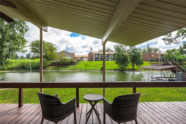 deck with a water view and a yard