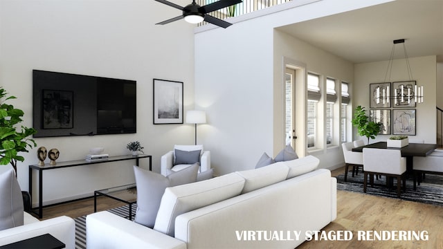 living room with ceiling fan with notable chandelier and hardwood / wood-style floors