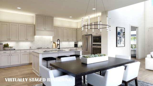 kitchen with light hardwood / wood-style floors, appliances with stainless steel finishes, decorative backsplash, and a kitchen island with sink