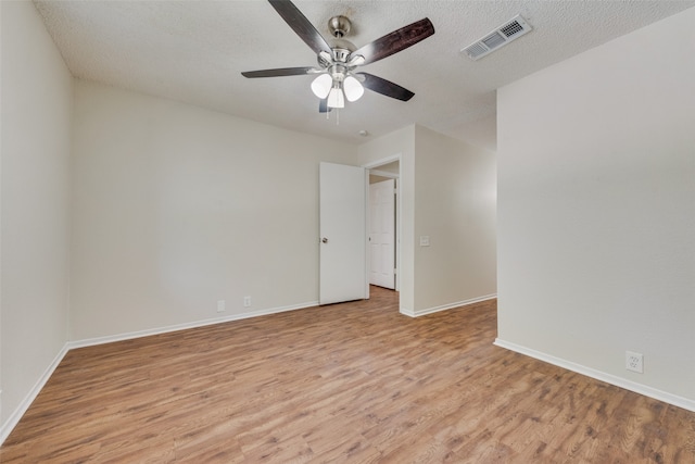 unfurnished room featuring ceiling fan, light hardwood / wood-style floors, and a textured ceiling