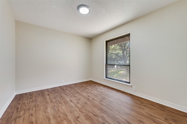 empty room with a textured ceiling and hardwood / wood-style floors